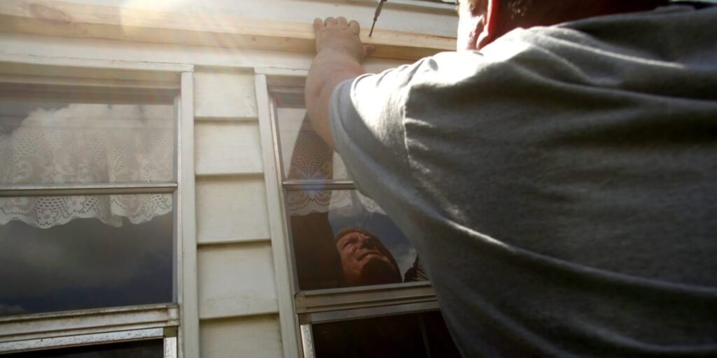 bradenton-fl---september-08--evan-corley-works-to-install-plywood-over-his-homes-windows-as-resid